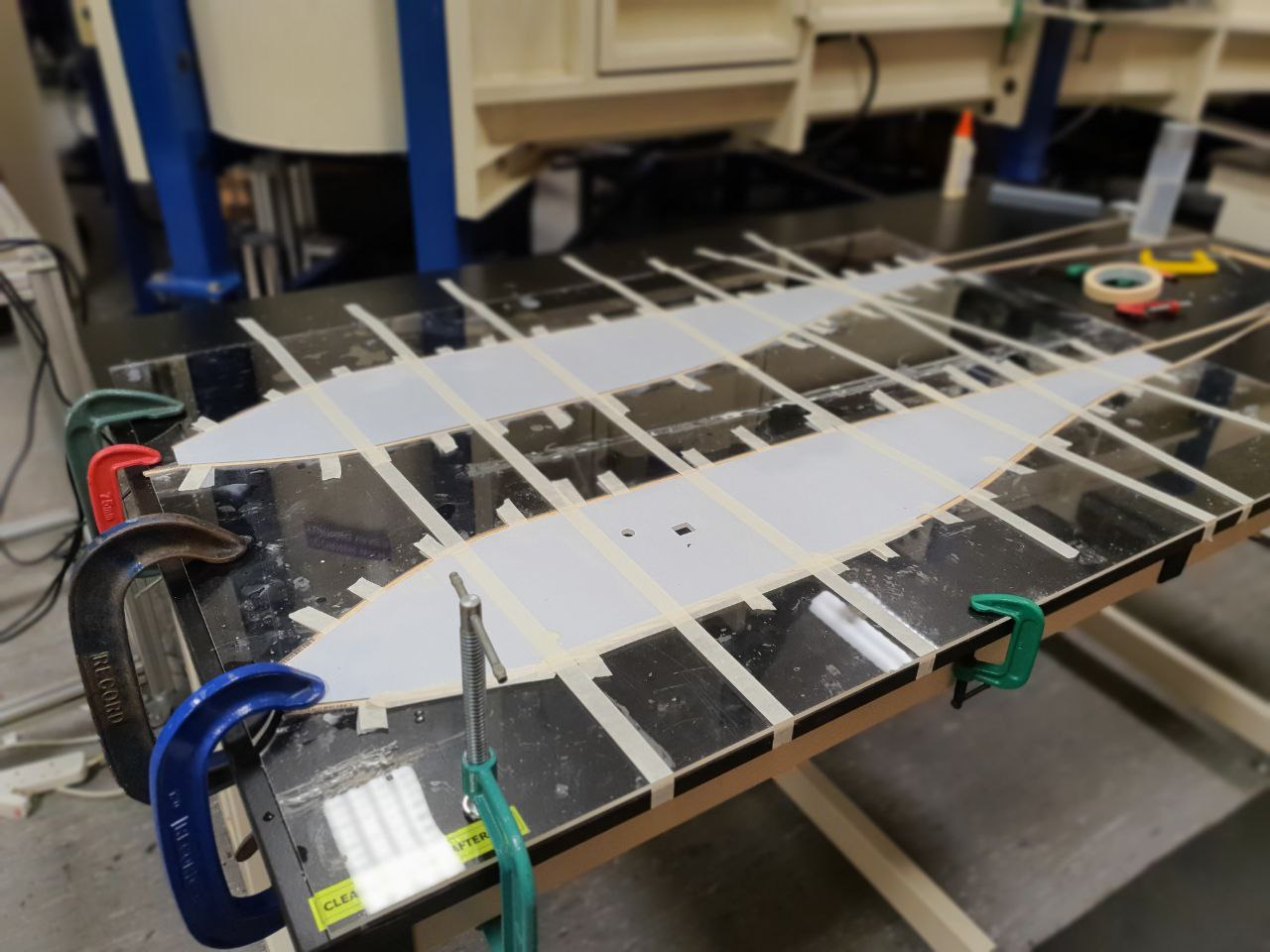 Using a laser cut jig to create bent stringers for our prototype fuselage. We did not use this process in our final plane because the manufacturing time was not worth the gain in aerodynamics.